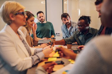 Çeşitli meslektaşlar, yeni projeleri için yeni fikirleri tartışırken ofiste beyin fırtınası yaparken eğleniyorlardı. Çok ırklı iş arkadaşları toplantıda fikir alışverişinde bulunmak üzere toplantı odasında toplandılar..
