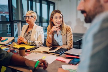 Modern bir ofiste eğlenceli, çok ırklı, yaratıcı genç insanlar. Yaratıcı ortak çalışma alanında birlikte çalışan farklı insanlardan oluşan bir grup. Eğlenceli insanlarla çalışmak. Kafkasyalı güzel bir kadına odaklan..