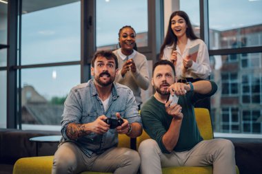 İş molasında ofiste video oyunu oynayan çeşitli iş adamları. Dost canlısı bir atmosferde birlikte çalışan çok ırklı meslektaşlar..