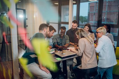 Çeşitli meslektaşlar, yeni projeleri için yeni fikirleri tartışırken ofiste beyin fırtınası yaparken eğleniyorlardı. Çok ırklı iş arkadaşları toplantıda fikir alışverişinde bulunmak üzere toplantı odasında toplandılar..