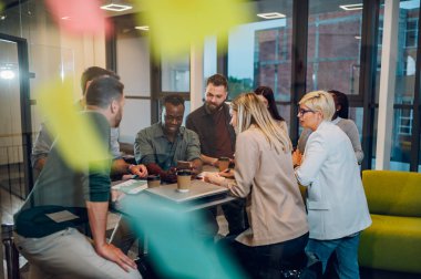 Modern bir ofiste eğlenceli, çok ırklı, yaratıcı genç insanlar. Yaratıcı ortak çalışma alanında birlikte çalışan bir grup farklı iş adamı. Eğlenceli insanlarla çalışmak. Cam duvarın içinden ateş etti..