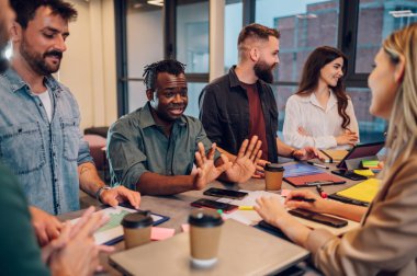 Çeşitli meslektaşlar, yeni projeleri için yeni fikirleri tartışırken ofiste beyin fırtınası yaparken eğleniyorlardı. Çok ırklı iş arkadaşları toplantıda fikir alışverişinde bulunmak üzere toplantı odasında toplandılar..