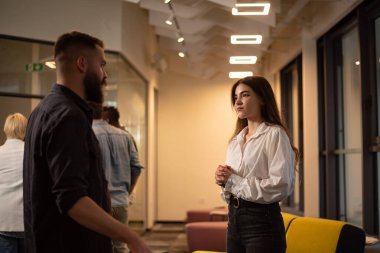 Ofiste sohbet eden iki iş adamı. Heyecanlı bir kadın erkek arkadaşıyla fikir paylaşımı ya da yeni bir iş planı yapıyor. İş molası kavramı. Çok ırklı takım.