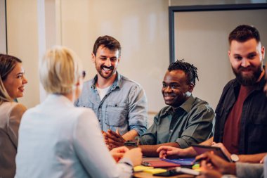 Şirket brifinginde birlikte çalışan mutlu çok ırklı iş ekibi konferans odasında toplandı. Yönetim kurulundaki çeşitli meslektaşlarım iş konuşuyorlar. Afro-Amerikan bir adama odaklan.