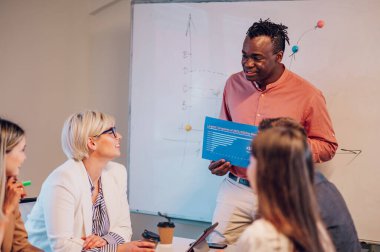 Çeşitli yaratıcı iş adamları modern bir şirketin toplantı odasında birlikte çalışıyorlar. Beyin fırtınası konsepti. Ofis hayatı. Çok ırklı iş arkadaşları. Afrika kökenli Amerikalı erkek patron toplantı yapıyor..