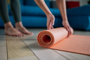 Kadın, evdeki meditasyon yogası için oturma odasında paspas çeviriyor. Etkin yaşam biçimi.