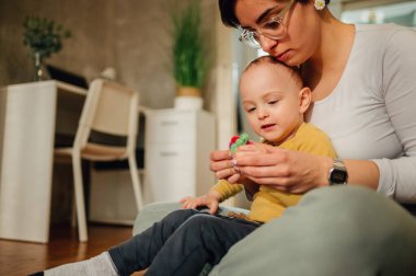 Anne ve oğul, oyunlar boyunca kilden şekil alıyor ve motor becerilerini geliştiriyor. Bebek bakıcısı ya da teyzesiyle oynayan küçük bir çocuk. Çocuk konsepti için komik eğitici oyunlar. Boşluğu kopyala.