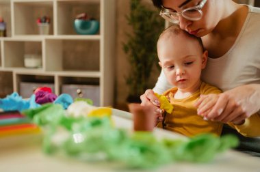 Oyunlar boyunca kil ve motor becerilerini geliştiren iki eğlenceli nesne. Küçük çocuk annesi ya da teyzesiyle oynuyor. Çocuk konsepti için komik eğitici oyunlar. Boşluğu kopyala.