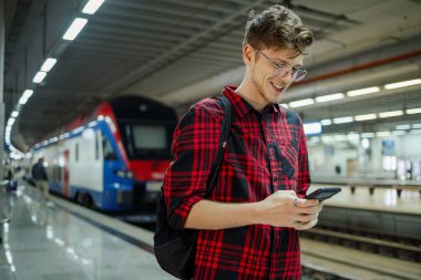 İşe gidip gelen hippi ya da telefon kullanırken trenle ya da metroyla giden bir okul. Genç erkek, istasyondayken e-posta okuyor ya da cep telefonuna mesaj yazıyor. Boşluğu kopyala.