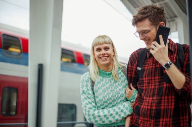 Tren istasyonunda trenlerini bekleyen romantik genç bir çiftin portresi. Uzak mesafe ilişkisi ya da birlikte seyahat eden öğrenciler. Boşluğu kopyala.