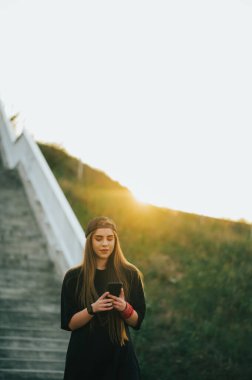 Dışarıda akıllı telefon kullanan genç ve şık bir kadın.