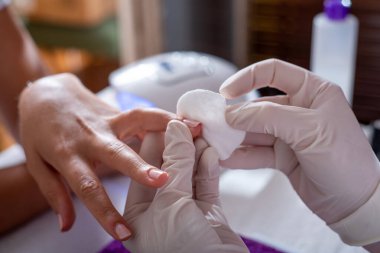 Manikürü bitiren bir güzellik uzmanının fotoğrafı.