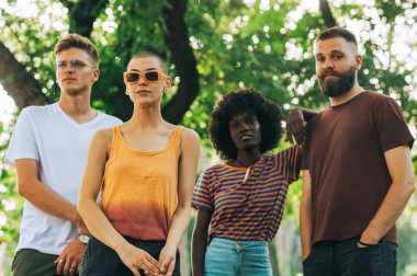 Doğada duran ve poz veren çok kültürlü z arkadaşlarının portresi. Şehir parkında poz veren ve kameraya bakan farklı nesiller. Doğadaki modaya uyan hippi arkadaşlarının portresi..