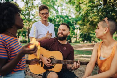 Hippiler parkta gitar çalarak ve müzik dinleyerek eğleniyorlar. Dünya günü. Eko arkadaşlar doğada gitar çalarak bir gün geçiriyorlar. Çevreci, güneşli günü müzik ve arkadaşlıkla kutluyor..