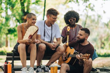 Değişim öğrencilerinden oluşan çok kültürlü bir grup şehir parkında oturuyorlar ve reçel seansı yapıyorlar. Afrikalı Amerikalı bir kız şarkı söylerken bir sanatçı gitar çalıyor. Diğer arkadaşlar dinliyor ve eğleniyorlar..