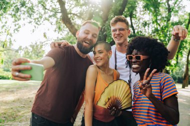 Dünya gününde doğada selfie çeken dört tane çok kültürlü çevrecinin portresi. Doğada selfie çeken ve birlik ve çeşitliliği kutlayan bir grup genç çevreci.