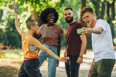 Bir grup çok kültürlü şehirli arkadaş komik pozlar veriyor ve selfie çekerken aptalca davranıyorlar. Havalı hippi arkadaşlar şehir parkında durup hatıralar ediniyorlar. Moda gençleri birlikte eğleniyor.