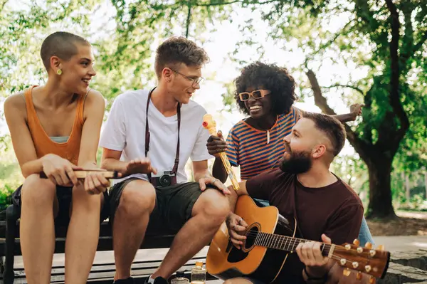 Çok kültürlü gezgin müzisyenlerden oluşan küçük bir grup parkta oturmuş, reçel seansı yapıyorlar. Bir adam şarkı söylerken, mutlu bir hippi sanatçı gitar çalıyor. Bir sokak müzisyeni prova yapıyor..