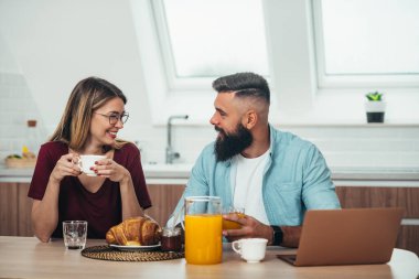 Genç ve mutlu bir çiftin evde kahvaltısını yaparken çekilmiş.