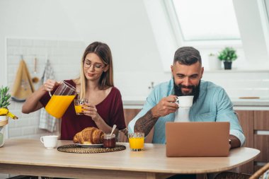 Genç ve mutlu bir çiftin evde kahvaltı etmesi.