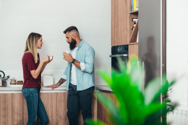 Genç ve çekici bir çift sabahları evde kahve içerken birlikte vakit geçiriyorlar.