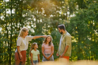 Sevecen bir anne ve baba iki kızıyla birlikte doğada duruyor ve güneşli güzel bir yaz gününü dışarıda geçiriyorlar. Aile hafta sonunu doğada geçirip birlikte kaliteli zaman geçireceğiz..