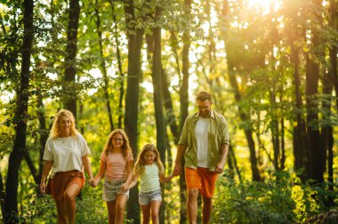 Maceracı bir aile ormanda el ele tutuşuyor ve yürüyüş yaparken doğayı keşfediyor. Mutlu bir ailenin portresi güneşli bir yaz gününü doğada birlikte geçiriyor. Vahşi doğayı keşfeden genç bir aile..