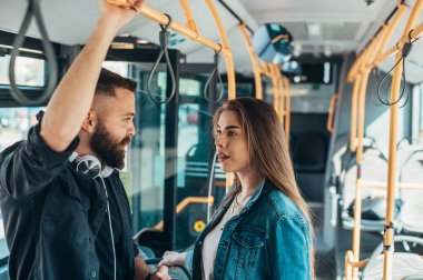 Genç çift otobüs sürerken konuşuyor ve flört ediyor.