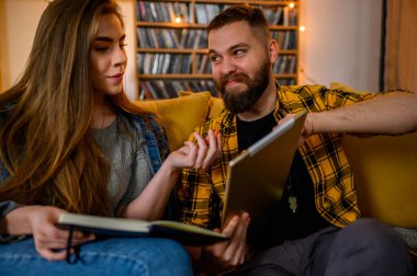 Evde birlikte sınava çalışırken dijital tablet kullanan iki genç öğrenci.