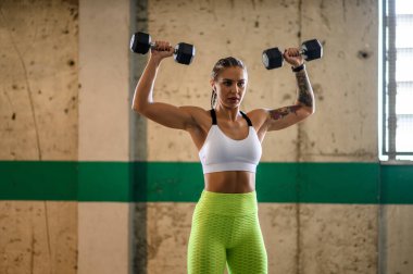 Dambıl ve hava podu kullanırken dışarıda antrenman yapan çekici bir kadın.