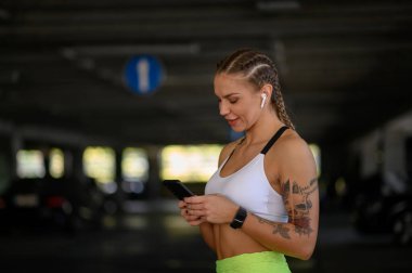 Dışarıda eğitimini tamamladıktan sonra akıllı telefon ve hava kapsülleri kullanan güzel ve çekici bir kadın.