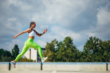 Şehir ortamında eğitim görürken koşan çekici bir genç kadın.