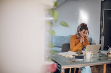 Harika bir iş kadını, konferans sırasında dizüstü bilgisayar ve hava kapsülleri kullanıyor ve evden çalışıyor. Serbest Çalışanlar için alternatif ofis kavramı.