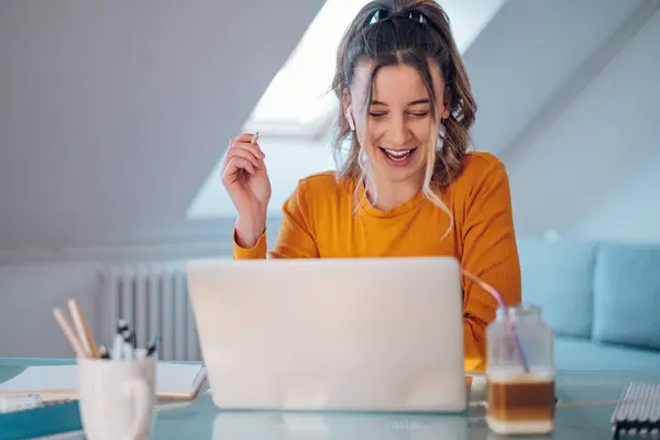 stock image Smiling caucasian woman having web call on a laptop while working at home. Video Conference. Young woman with digital gadgets.