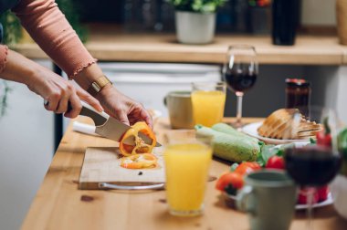 Yaşlı kadın, mutfakta sebze keserken ve evde yemek pişirirken ailesi için yemek hazırlıyor. Modern bir mutfakta kıdemli bir kadın ve ev yapımı lezzetli yemekler yapıyor..