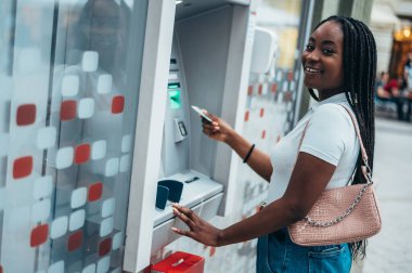 Güzel, Afro-Amerikalı bir kadın kredi kartı kullanıyor ve ATM 'den para çekiyor.