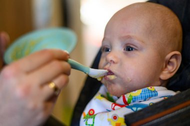 Annem onu beslerken bebek maması yiyen sevimli bir bebek.