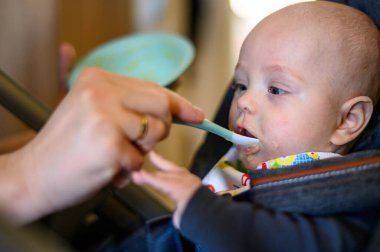 Annem onu beslerken bebek maması yiyen sevimli bir bebek.