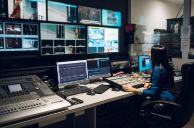 Televizyon istasyonunda yayın kontrol odasında yapımcı olarak çalışan orta yaşlı güzel bir kadın. Prodüksiyon yapımcısı. Televizyon..