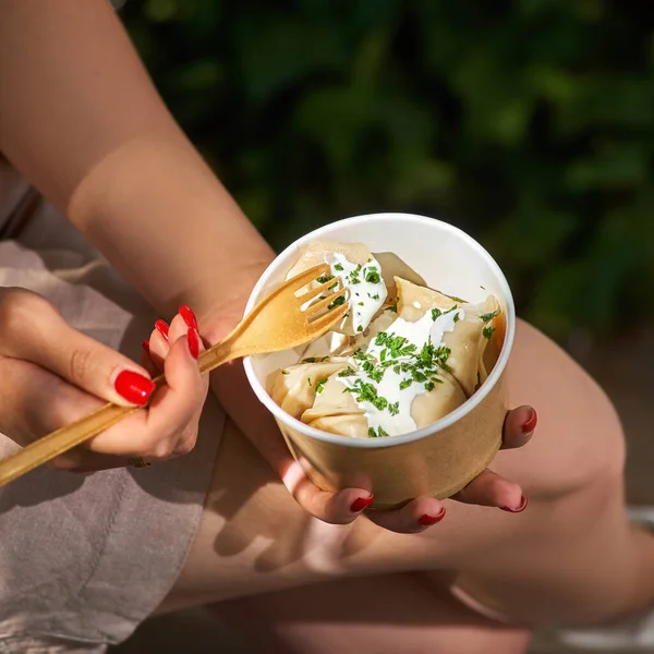 stock image boiled ravioli with parsley, Traditional pelmeni, ravioli, dumplings filled with meat in takeaway box in female hands, mockup