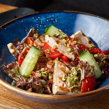 Izgara tavuk göğsü. Kızarmış tavuk fileto ve taze sebze salatası domates, salatalık ve roka yaprakları. Salatalı tavuk eti. Sağlıklı yemek..