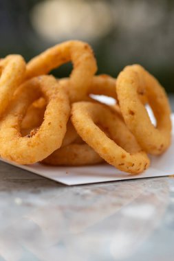 Fast Food Restoranı, yemek teslimatı, paket yemek, soğan halkaları ve soslu kağıt kaplar. menü, yakın plan
