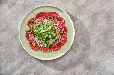 Mermer etli carpaccio roka, kapari ve parmesan peyniri.