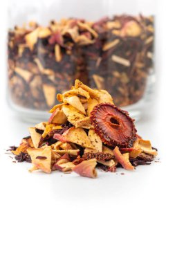 Hibiscus tea, Mixture herbal floral fruit tea with pieces of strawberry and red apple on white background.