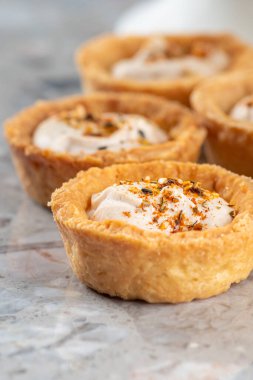 Tartlets with chicken, boiled eggs, spices and herbs. Traditional cold portioned appetizer in a pastry basket. Close-up.