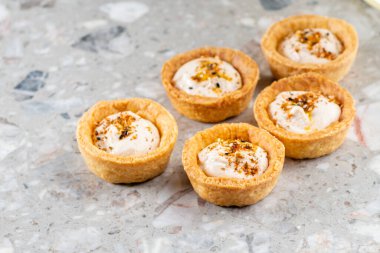 Tartlets with chicken, boiled eggs, spices and herbs. Traditional cold portioned appetizer in a pastry basket. Close-up.
