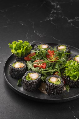 Siyah pirinç, avokado ve siyah tabakta tatlı patatesli vejetaryen suşisi. Vejetaryen gıda konsepti.