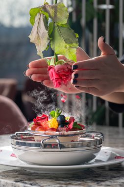 Dondurmalı tatlı, böğürtlen ve azot içinde donmuş gül yaprakları. Lokantada servis edilen tatlı tarifi konsepti.