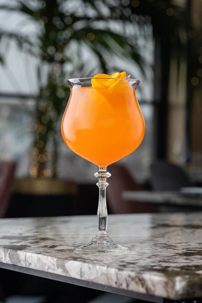 アペロールはアルコールカクテルです オレンジだ 氷のキューブで冷たい飲み物 ガラスはバーにあります 背景は緑 背景がぼやけている レストラン カフェ バーのメニュー — ストック写真