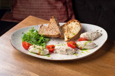 Tabağında kahverengi ekmek olan morina ciğeri ezmesi. Morina ciğeri ve süzme peynirden yapılmış ev yapımı. Sağlıklı yemek.